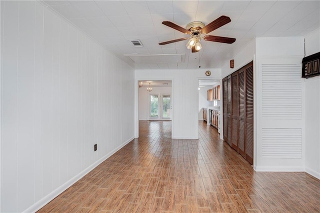 interior space featuring ceiling fan with notable chandelier and hardwood / wood-style flooring