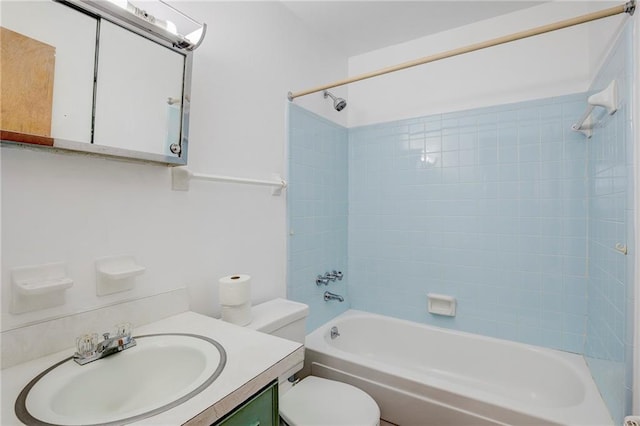 full bathroom featuring vanity, tiled shower / bath combo, and toilet