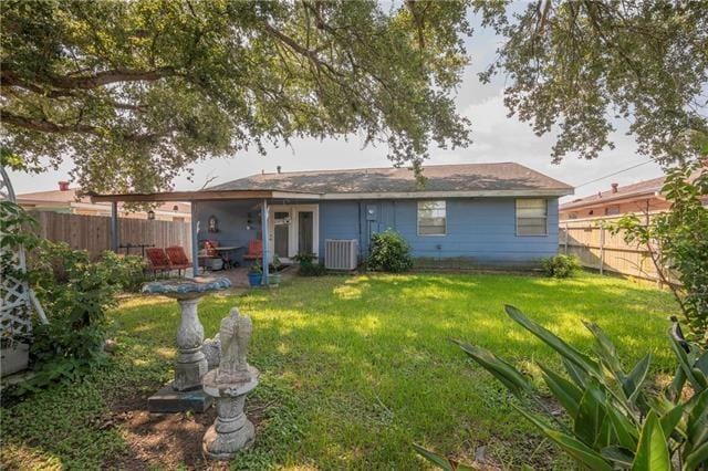 back of house featuring central air condition unit, a patio area, a lawn, and french doors