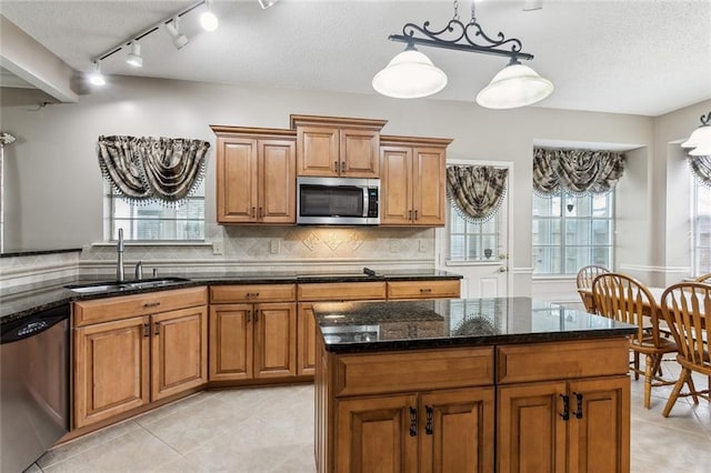 kitchen featuring sink, hanging light fixtures, plenty of natural light, and stainless steel appliances