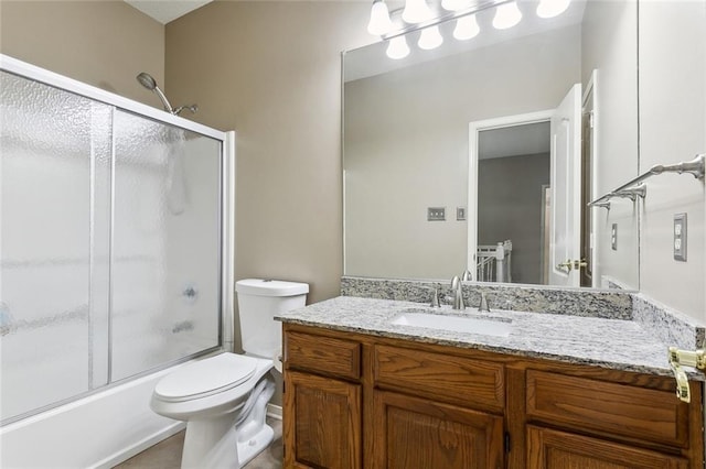 full bathroom featuring vanity, bath / shower combo with glass door, and toilet