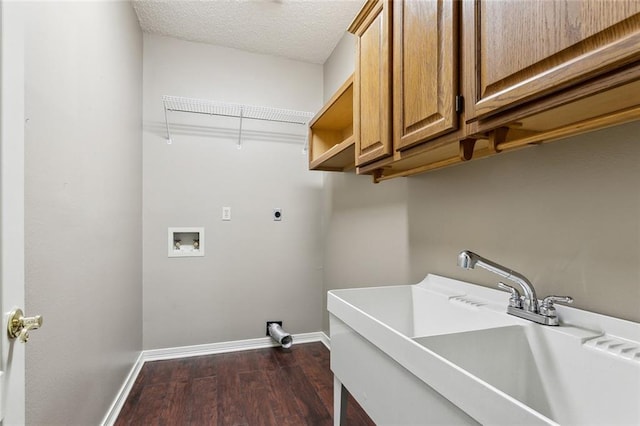 washroom with cabinets, a textured ceiling, hookup for a washing machine, dark hardwood / wood-style floors, and sink