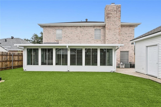 rear view of property featuring a lawn and a sunroom