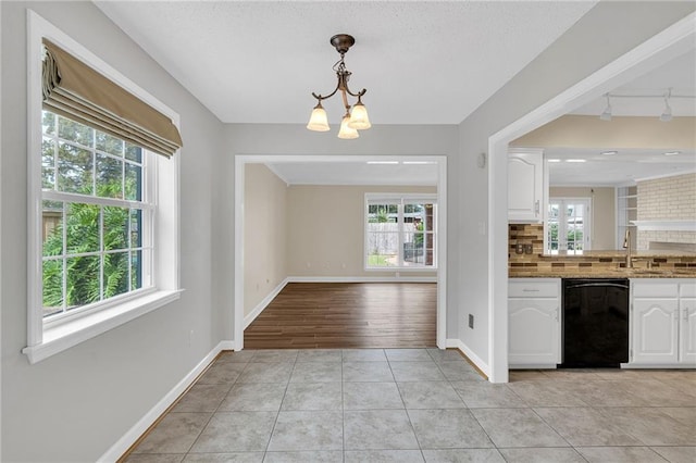 kitchen featuring dishwasher, white cabinetry, and a healthy amount of sunlight