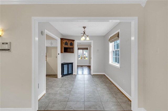 unfurnished dining area with light tile patterned floors and crown molding