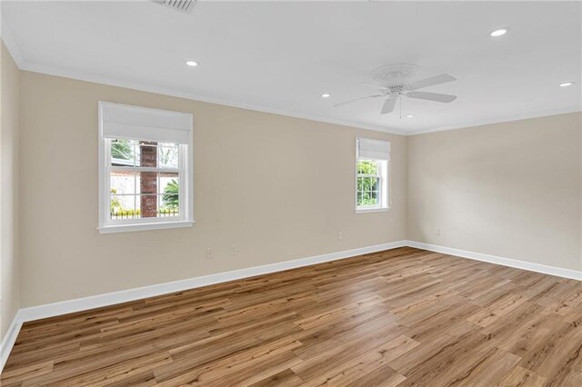 empty room with plenty of natural light, ornamental molding, and light wood-type flooring