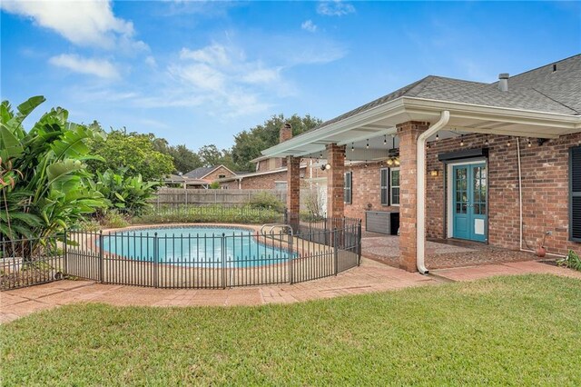 view of swimming pool featuring a lawn, ceiling fan, and a patio area