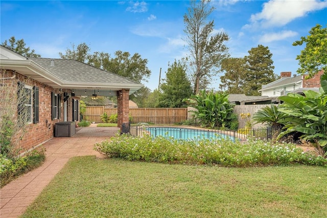 view of yard featuring a fenced in pool, a patio area, and ceiling fan