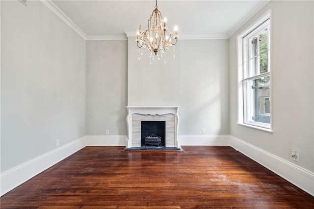 unfurnished living room with hardwood / wood-style flooring, crown molding, and a notable chandelier