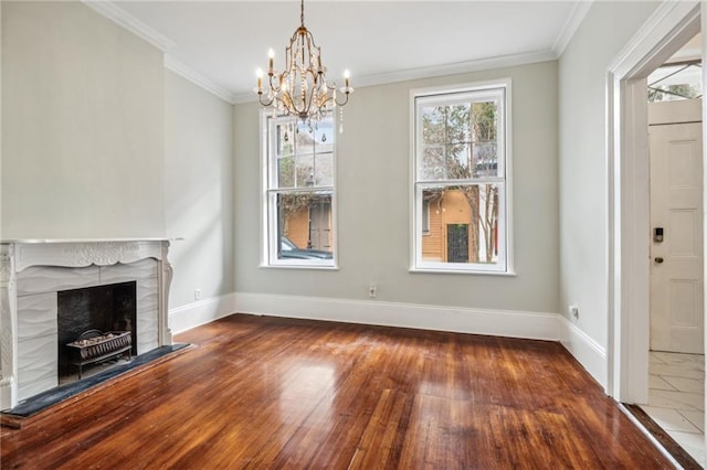 unfurnished living room with hardwood / wood-style floors, a fireplace, a chandelier, and ornamental molding