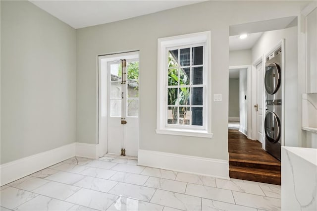 1216 Burgundy St, New Orleans, LA 70116 - laundry area with stacked washing machine and dryer, marble finish flooring, and baseboards