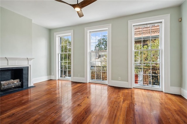 1216 Burgundy St, New Orleans, LA 70116 - unfurnished living room with hardwood / wood-style flooring, ceiling fan, baseboards, and a fireplace with flush hearth