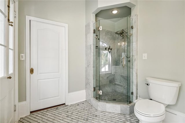 bathroom with tile patterned floors, toilet, and a shower with shower door