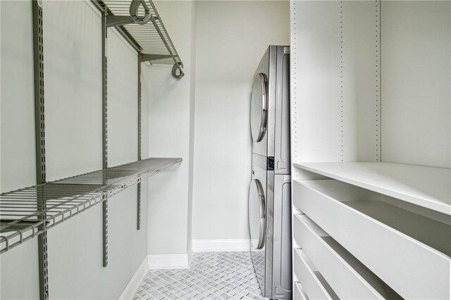 1216 Burgundy St, New Orleans, LA 70116 - laundry room with stacked washing machine and dryer, baseboards, and light tile patterned floors