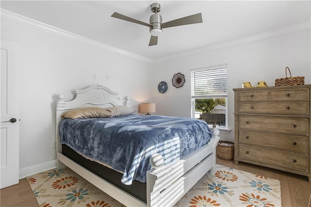 bedroom featuring light hardwood / wood-style flooring, ceiling fan, and crown molding