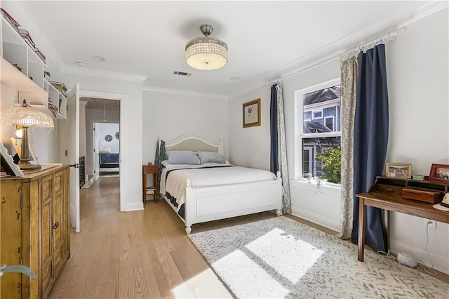 bedroom with light wood-type flooring and crown molding