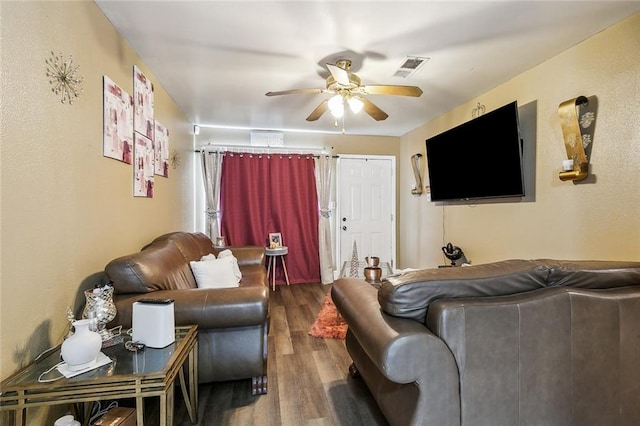 living room featuring ceiling fan and dark hardwood / wood-style floors