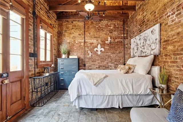 bedroom featuring beamed ceiling and brick wall