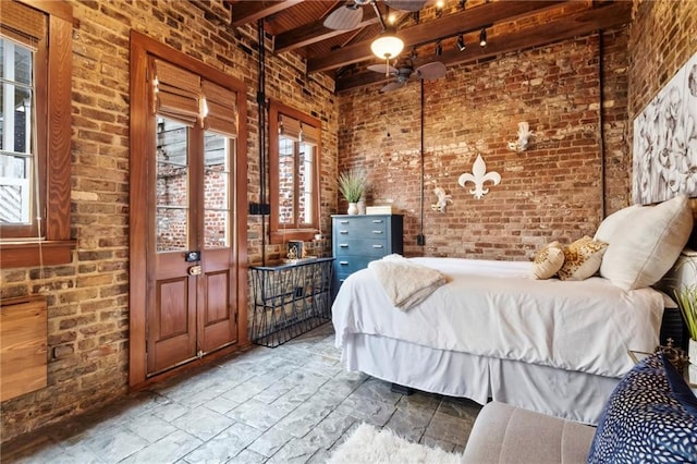 unfurnished bedroom featuring beam ceiling and brick wall