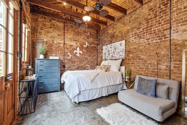 bedroom featuring beamed ceiling, ceiling fan, a towering ceiling, and brick wall