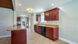 kitchen featuring black dishwasher and light tile patterned floors