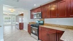 kitchen with light stone countertops, light tile patterned flooring, and electric stove