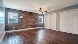 unfurnished bedroom featuring ceiling fan, dark hardwood / wood-style floors, and two closets