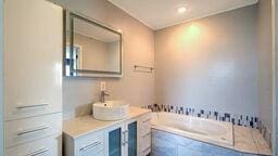 bathroom featuring vanity and a relaxing tiled tub