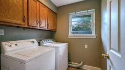 washroom with cabinets and washing machine and clothes dryer