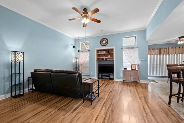 living room featuring hardwood / wood-style flooring, ceiling fan, built in features, and ornamental molding