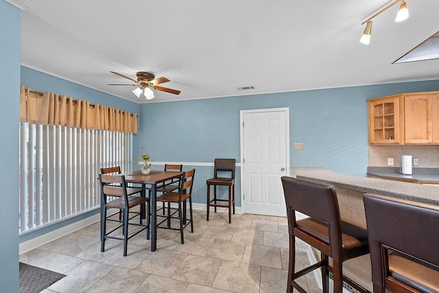 dining space featuring track lighting, ceiling fan, and crown molding