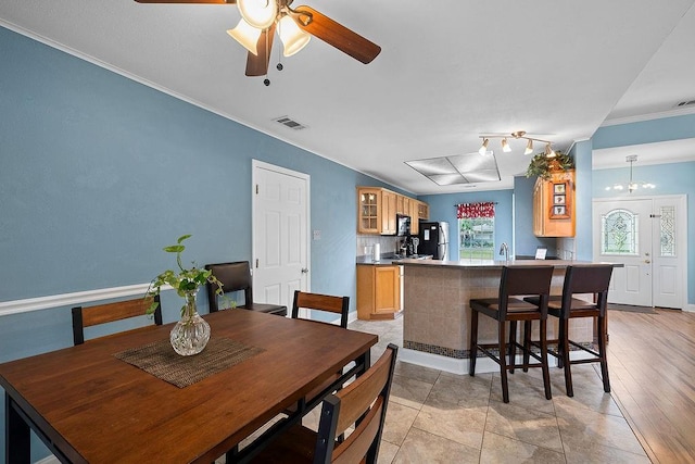 dining area with light hardwood / wood-style floors, ceiling fan, sink, and crown molding