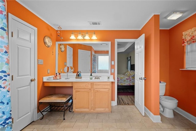 bathroom with toilet, vanity, tile patterned floors, and crown molding