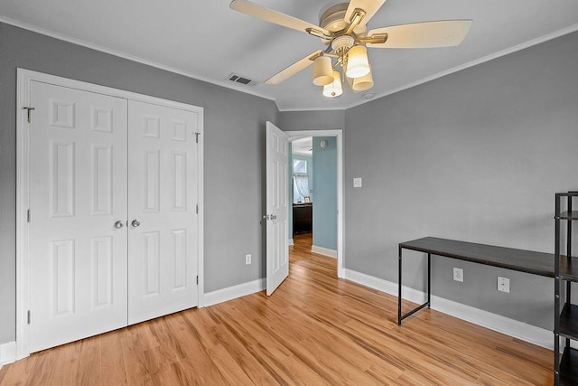 unfurnished bedroom with light hardwood / wood-style floors, ceiling fan, a closet, and ornamental molding