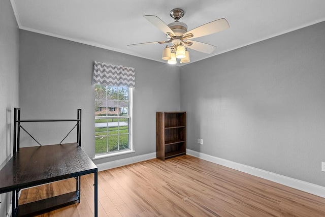 unfurnished office featuring ornamental molding, light wood-type flooring, and ceiling fan