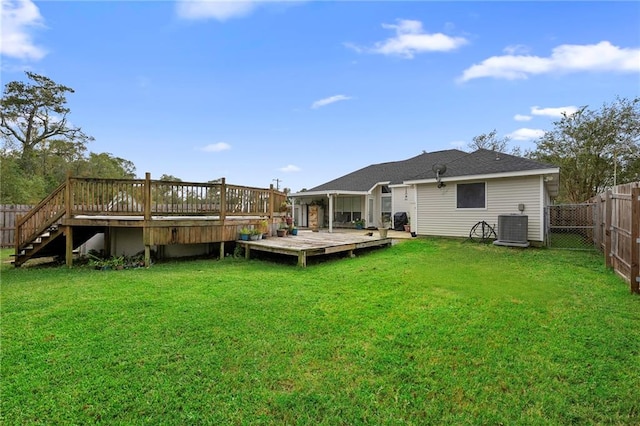 back of house featuring a wooden deck, cooling unit, and a lawn