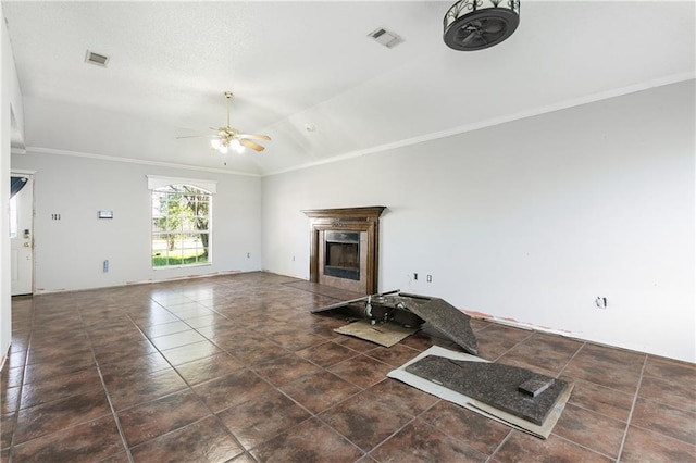 unfurnished living room featuring dark tile patterned floors, vaulted ceiling, ceiling fan, and crown molding