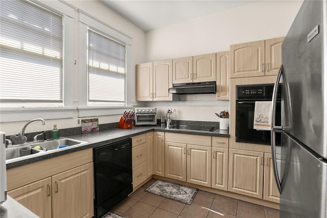 kitchen featuring light brown cabinets, black appliances, dark tile patterned floors, and sink