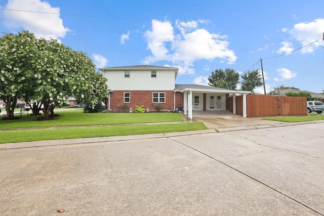 view of front of home with a front yard and a carport