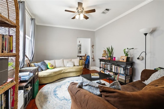 living room with ornamental molding, wood-type flooring, and ceiling fan