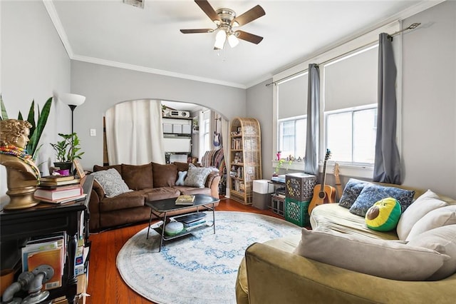 living room with dark wood-type flooring, ceiling fan, and crown molding