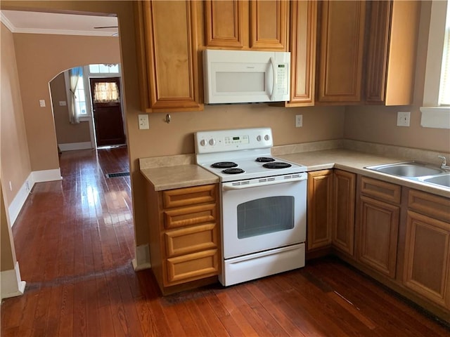 kitchen featuring white appliances, dark hardwood / wood-style floors, sink, and ornamental molding