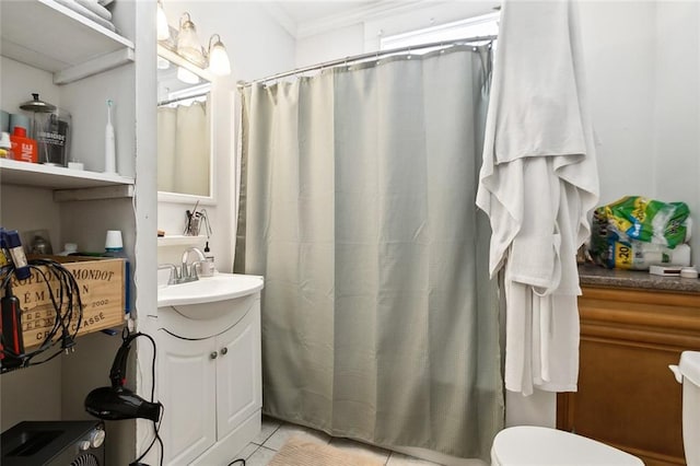 bathroom featuring tile patterned floors, toilet, ornamental molding, vanity, and walk in shower