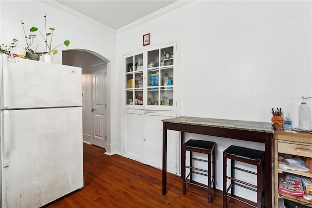 kitchen featuring dark wood-type flooring, white refrigerator, and crown molding