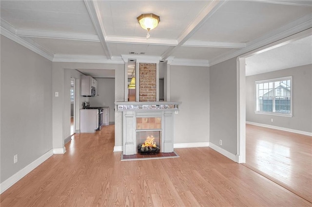 unfurnished living room with light hardwood / wood-style flooring, beam ceiling, coffered ceiling, a fireplace, and ornamental molding