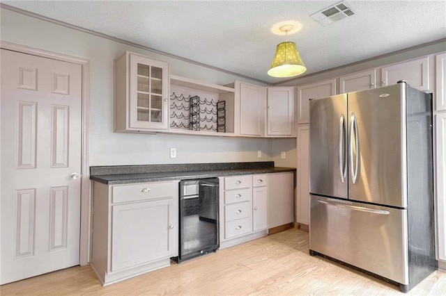 kitchen featuring light hardwood / wood-style flooring, beverage cooler, stainless steel refrigerator, and white cabinets