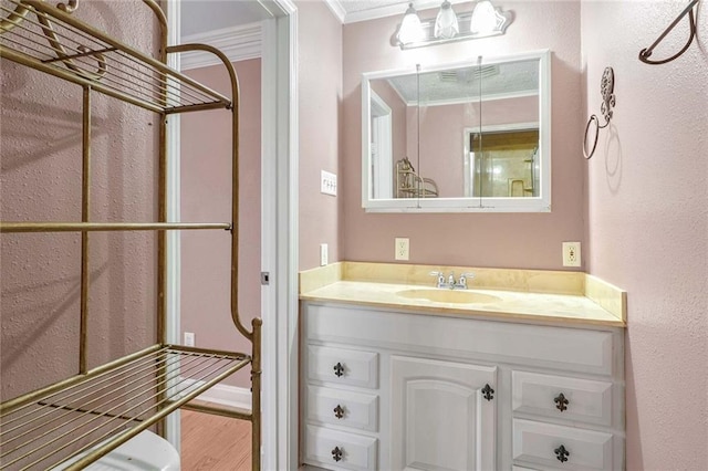 bathroom with crown molding, hardwood / wood-style floors, and vanity