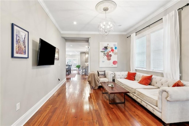 living room featuring a chandelier, hardwood / wood-style flooring, and ornamental molding