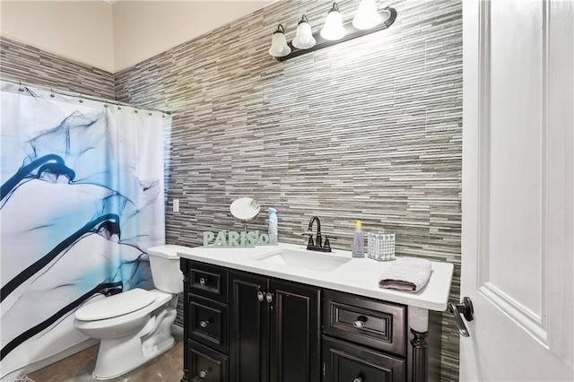 bathroom with toilet, vanity, curtained shower, and tile walls