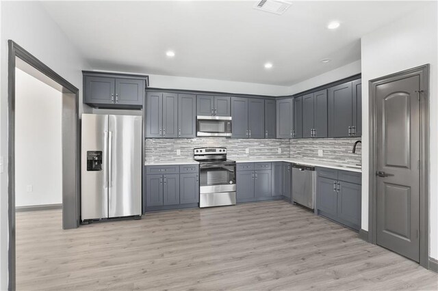 3227 Toledano St, New Orleans, LA 70125 - kitchen featuring appliances with stainless steel finishes, backsplash, light countertops, and recessed lighting